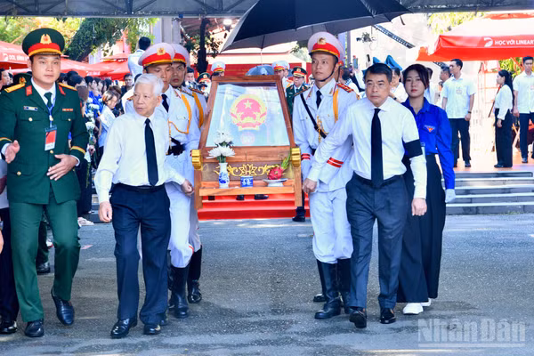 Nguyên Chủ tịch nước Nguyễn Minh Triết và Thủ tướng Chính phủ Lê Minh Hưng cùng thực hiện nghi thức đưa hài cốt các Anh hùng liệt sĩ từ Công viên Lê Thị Riêng về Nghĩa trang Liệt sĩ Thành phố Hồ Chí Minh. (Ảnh: THANH GIANG)