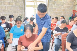 Cán bộ xã Cao Minh hướng dẫn người dân thôn Cốc Lải sử dụng các ứng dụng AI trên điện thoại thông minh (Ảnh ANH TUẤN) 