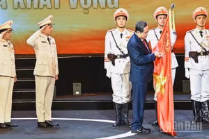 Chủ tịch Quốc hội Trần Thanh Mẫn gắn Huân chương Hồ Chí Minh lên lá cờ truyền thống của lực lượng Cảnh sát kinh tế. (Ảnh: DUY LINH)