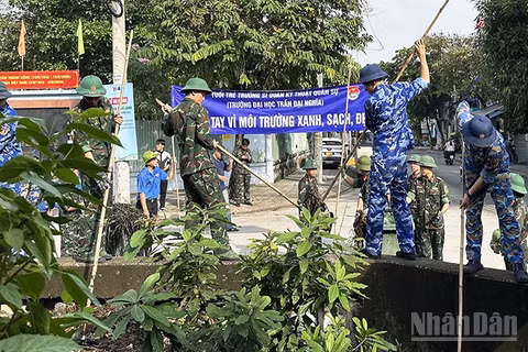 Thanh niên lực lượng vũ trang tham gia dọn vệ sinh, khơi thông dòng chảy rạch Nhà Nuôi. (Ảnh: HOÀNG LIÊM)