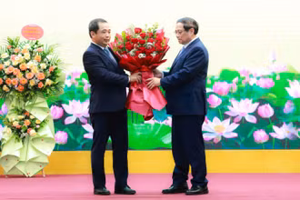 Thủ tướng Phạm Minh Chính tặng hoa chúc mừng quyền Bộ trưởng Nông nghiệp và Môi trường Trần Đức Thắng. (Ảnh: TRẦN HẢI)