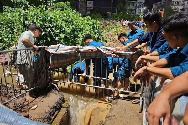Lực lượng cứu hộ cứu nạn tìm thi thể nam sinh viên rơi xuống cống tử vong tại phường Đông Ngạc. (Ảnh: Đức Tuấn)