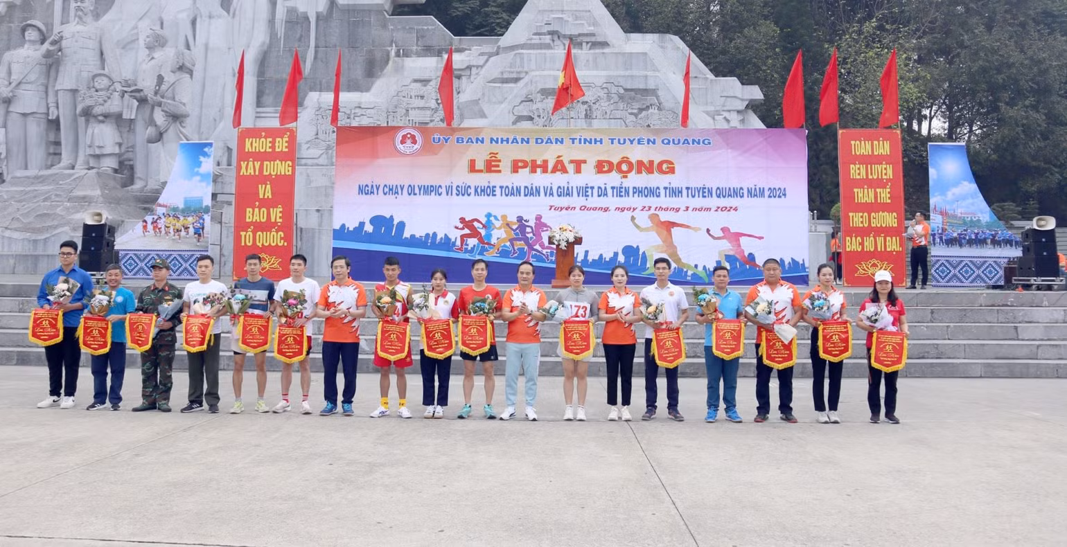 Đại biểu tặng cờ lưu niệm và hoa cho các đoàn tham gia ngày chạy Olympic.