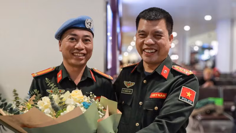 Trung tá Bùi Phương Lân nhận bó hoa tươi thắm từ đồng đội.