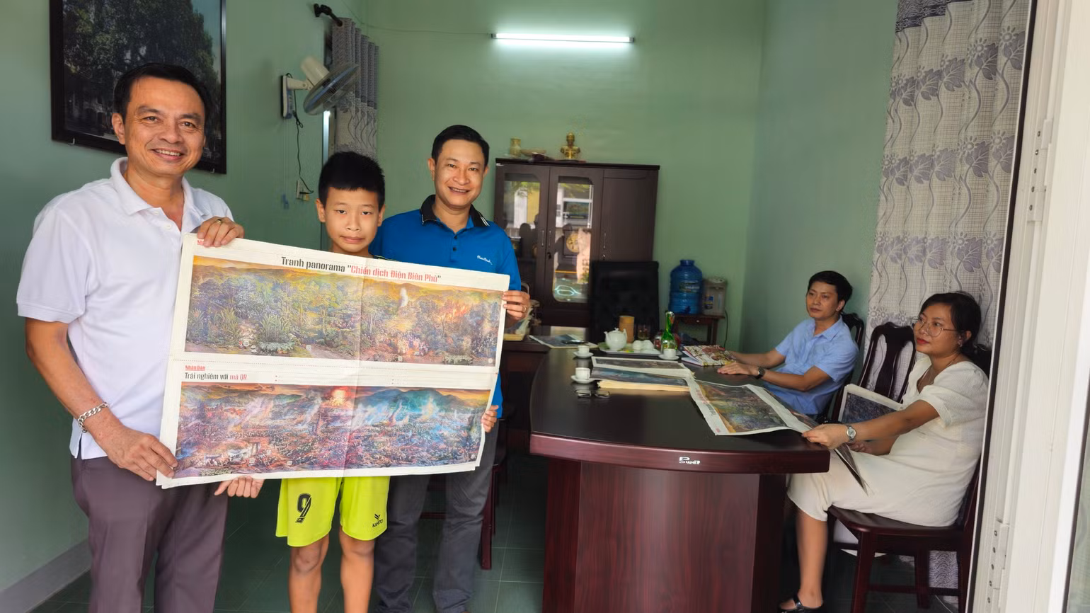 Học sinh THCS Quảng Trị được bố dẫn đến Văn phòng thường trú Báo Nhân Dân tại Quảng Trị nhận phụ trang số báo đặc biệt.