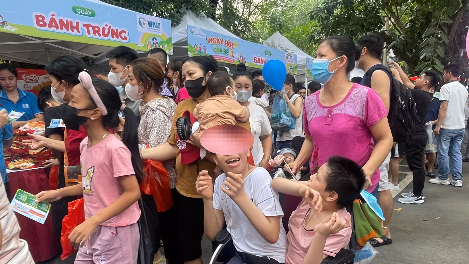 Chị Bùi Thị L. (xã Nghĩa Sơn, huyện Nghĩa Hưng, tỉnh Nam Định) đưa 2 con bị bại não đi nhận quà.