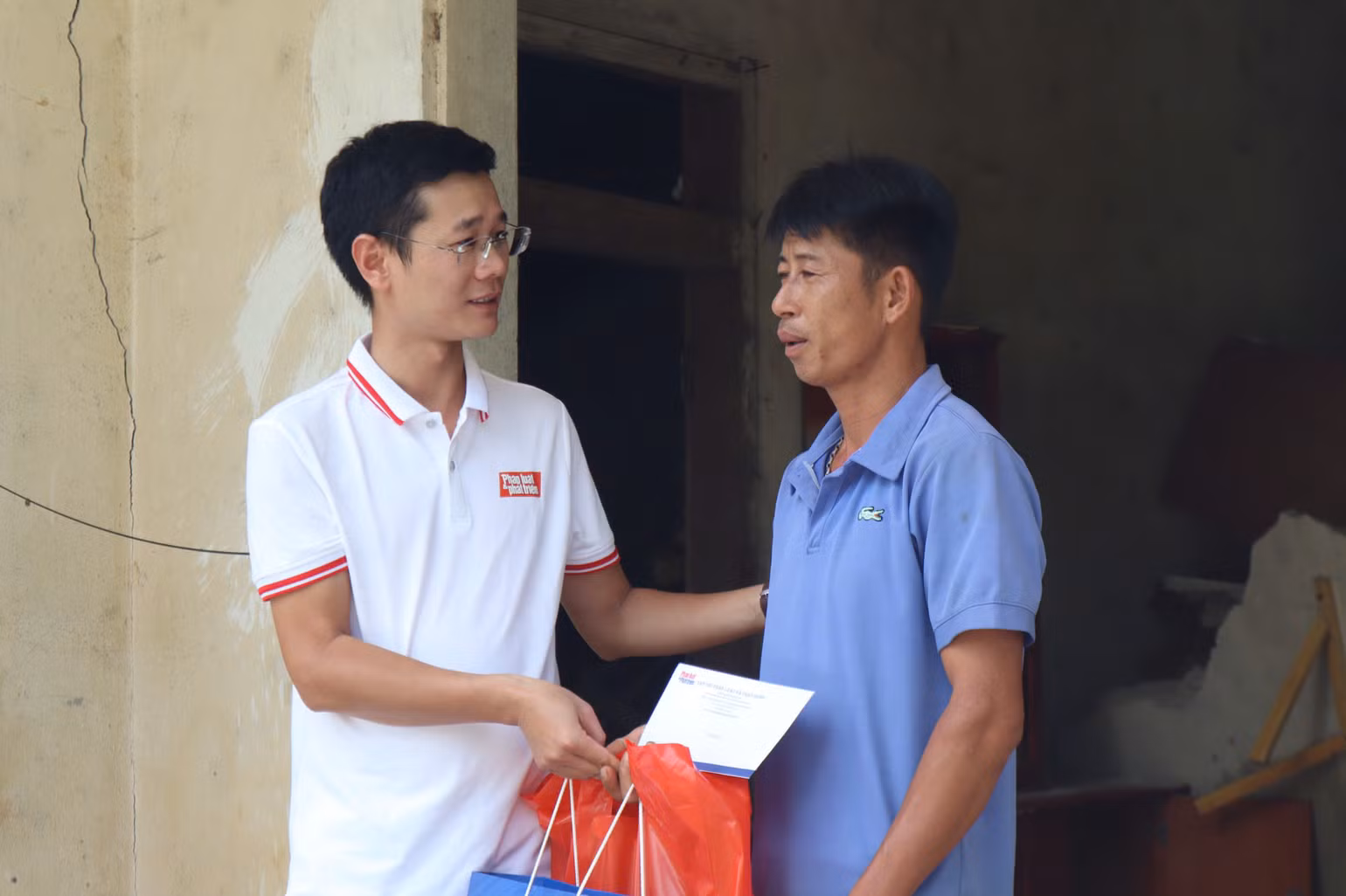Nhà báo Tiến Nguyên (Tạp chí Pháp luật và Phát triển) trao nhu yếu phẩm cho bà con ảnh hưởng lũ lụt tại huyện Bảo Yên, Lào Cai.