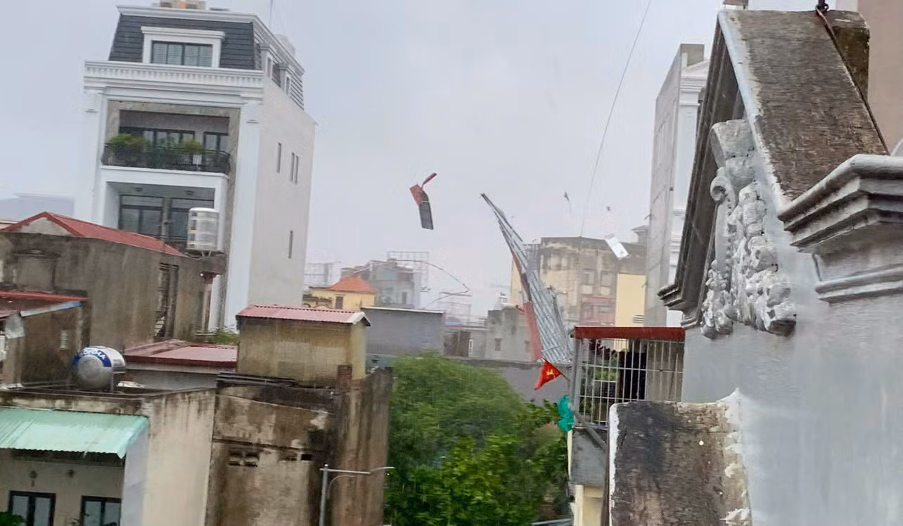 Ảnh mái tôn, bạt che, biển quảng cáo bay trong gió bão. (Ảnh: NGÔ QUANG DŨNG)