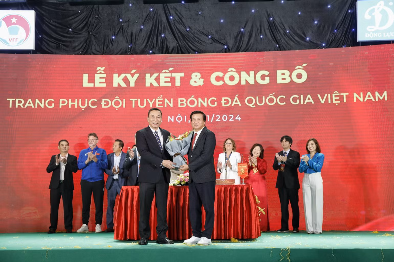 Chủ tịch VFF Trần Quốc Tuấn (bên trái) tặng hoa Chủ tịch Công ty Động Lực Lê Văn Thành.