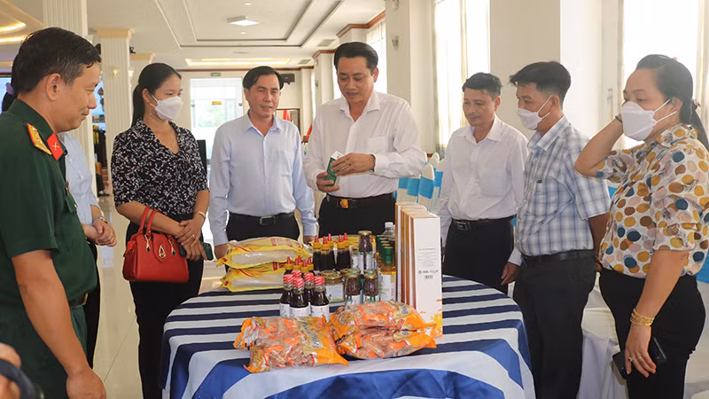 Đại biểu dự hội nghị đang tìm hiểu sản phẩm OCOP mật hoa dừa đạt hạng 5 sao.