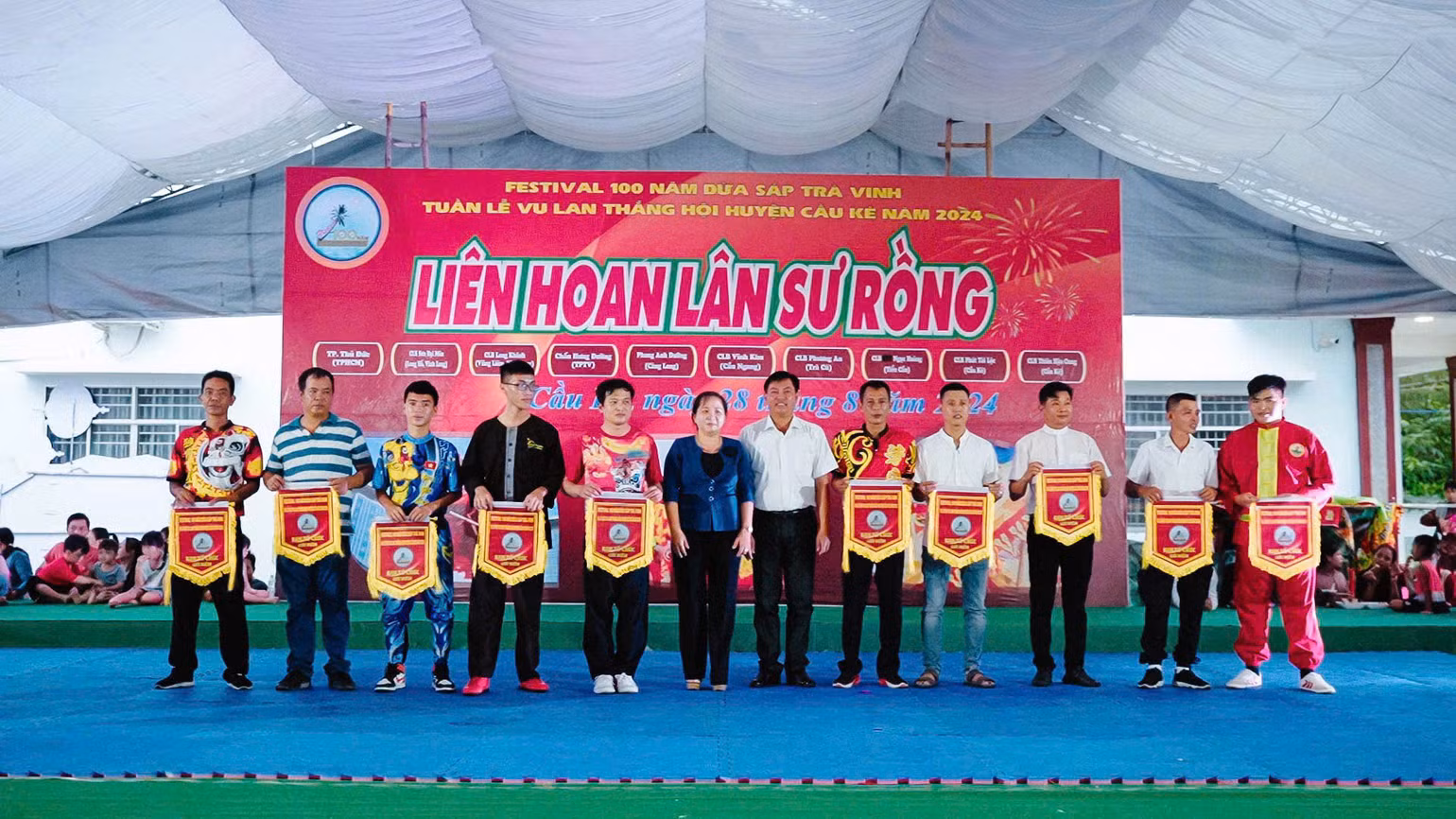 Đại diện các đội thi nhận cờ từ Ban tổ chức Liên hoan Lân Sư Rồng.