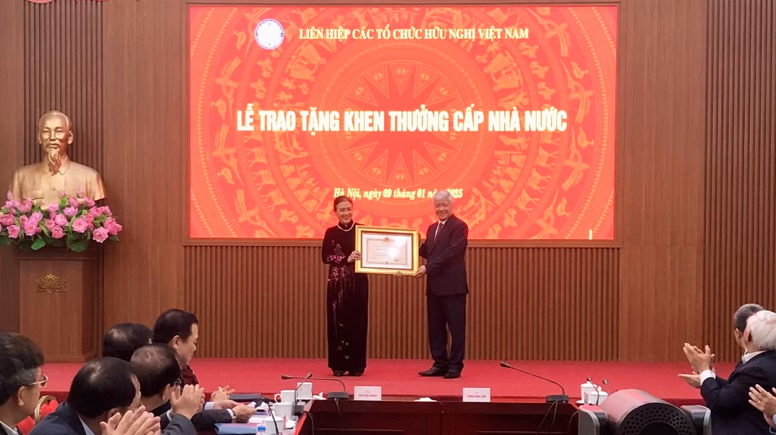 Đồng chí Đỗ Văn Chiến trao Huân chương Độc lập hạng Ba tặng bà Nguyễn Phương Nga.
