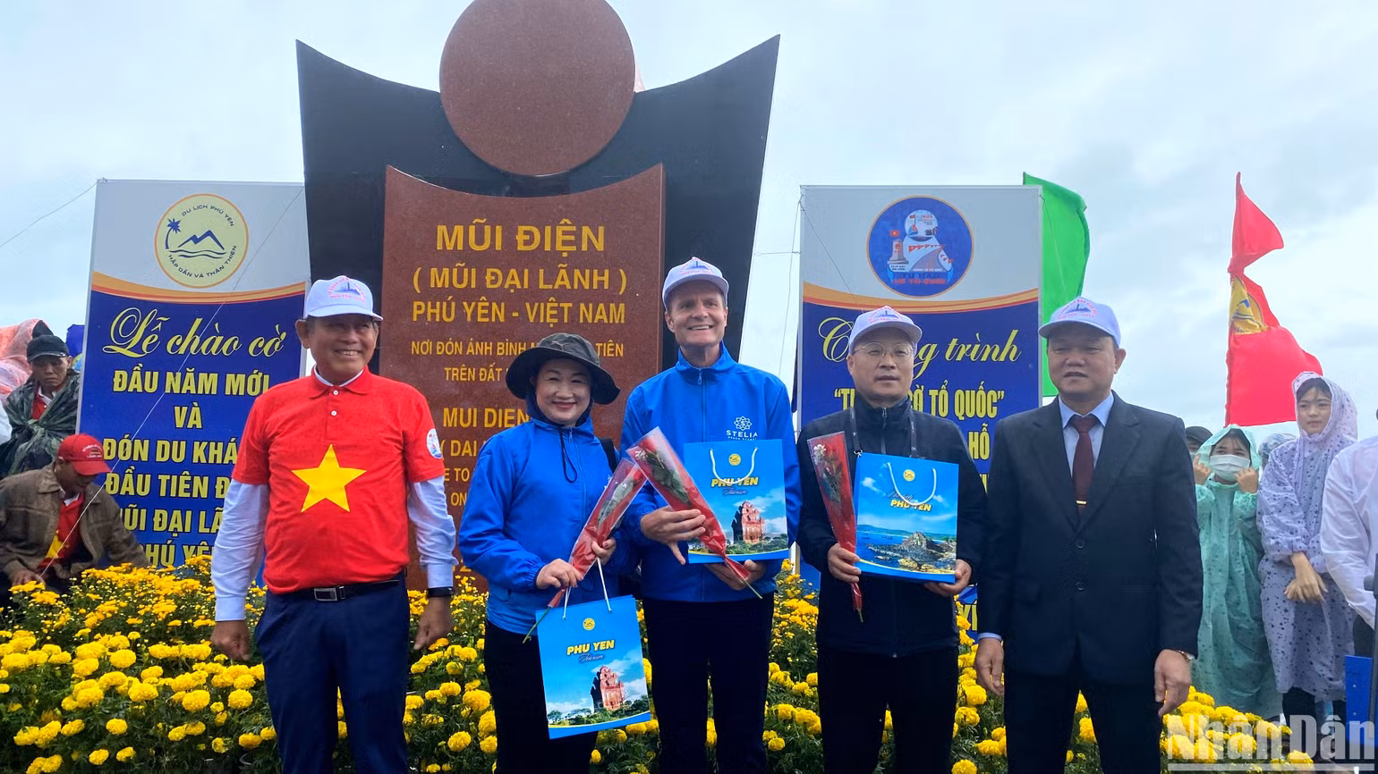 Đồng chí Trương Hòa Bình (bìa trái), nguyên Ủy viên Bộ Chính trị, nguyên Phó Thủ tướng Thường trực Chính phủ và ông Đào Mỹ, Phó Chủ tịch UBND tỉnh Phú Yên tặng hoa và quà cho du khách quốc tế đầu tiên đến tham quan Mũi Đại Lãnh năm mới 2023.