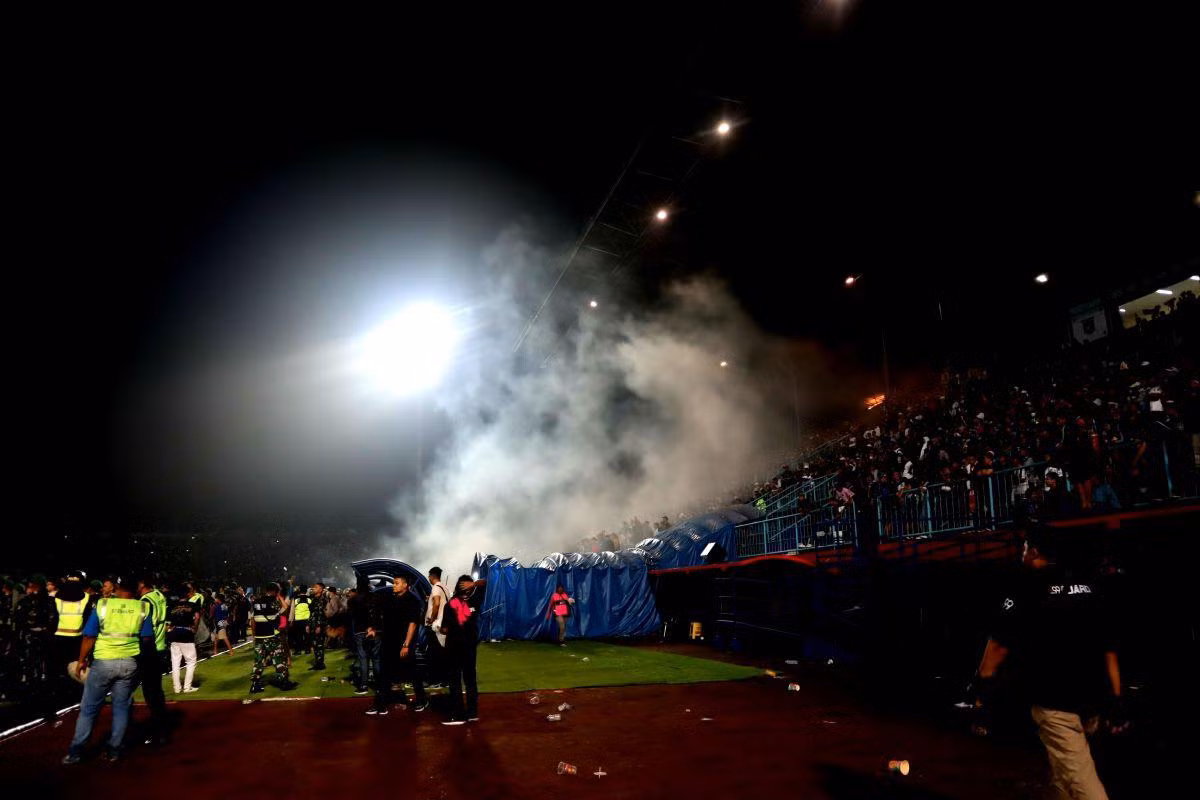 Bầu không khí trên sân đã trở nên rất nóng sau khi Arema FC để thua Persebaya Surabaya với tỷ số 2-3 trong trận “derby Đông Java” ở vòng 11 giải Liga 1 mùa giải 2022-2023. Đám đông cổ động viên đã không giữ được bình tĩnh, tràn vào sân gây náo loạn, khiến cảnh sát phải sử dụng hơi cay để vãn hồi trật tự. (Ảnh: KOMPAS)