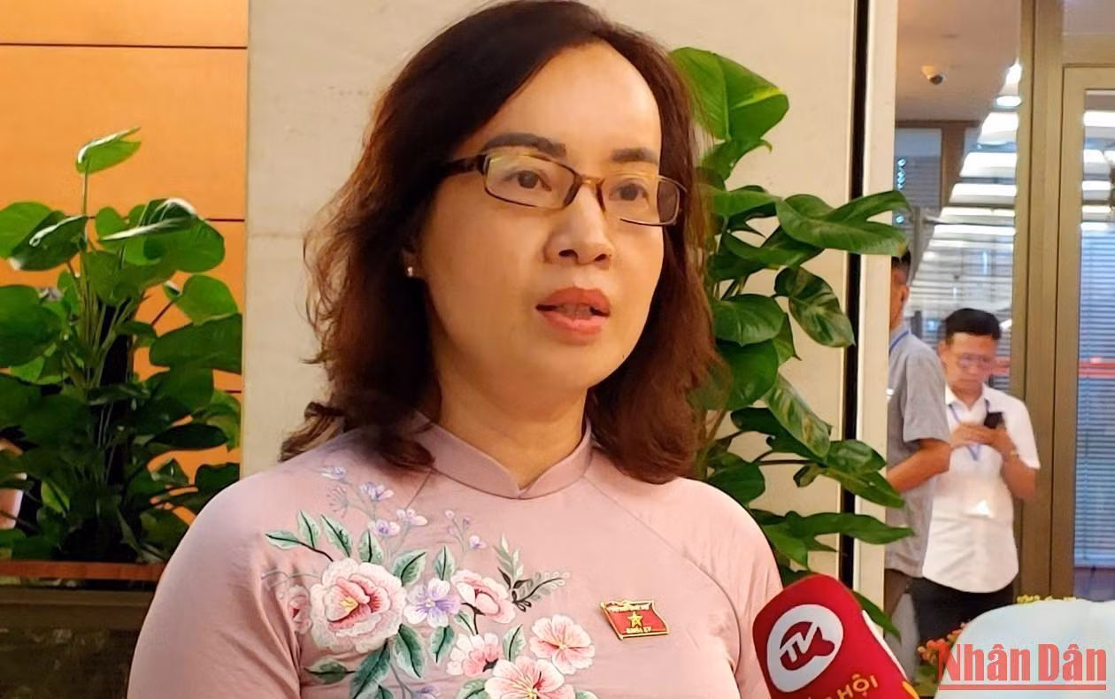 Đại biểu Nguyễn Thị Kim Anh (Bắc Ninh) trao đổi với các phóng viên bên hành lang Quốc hội. (Ảnh: TRUNG HƯNG)