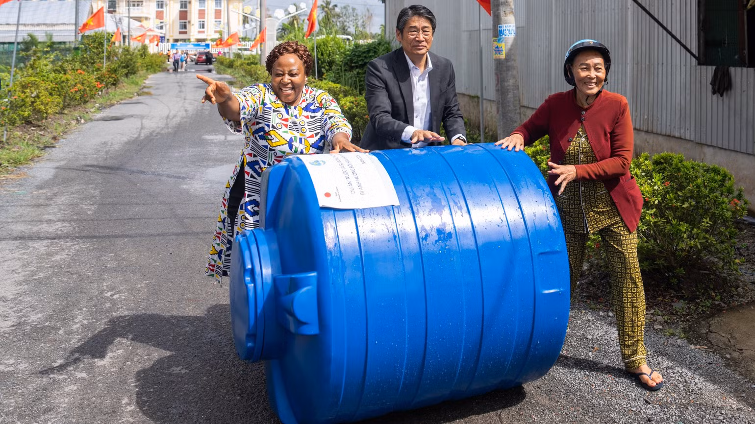 Trưởng Đại diện UN Women tại Việt Nam, bà Caroline Nyamayemombe và Đại sứ Nhật Bản tại Việt Nam, ông Ito Naoki cùng người dân Cà Mau chuyển bồn nước về nhà.
