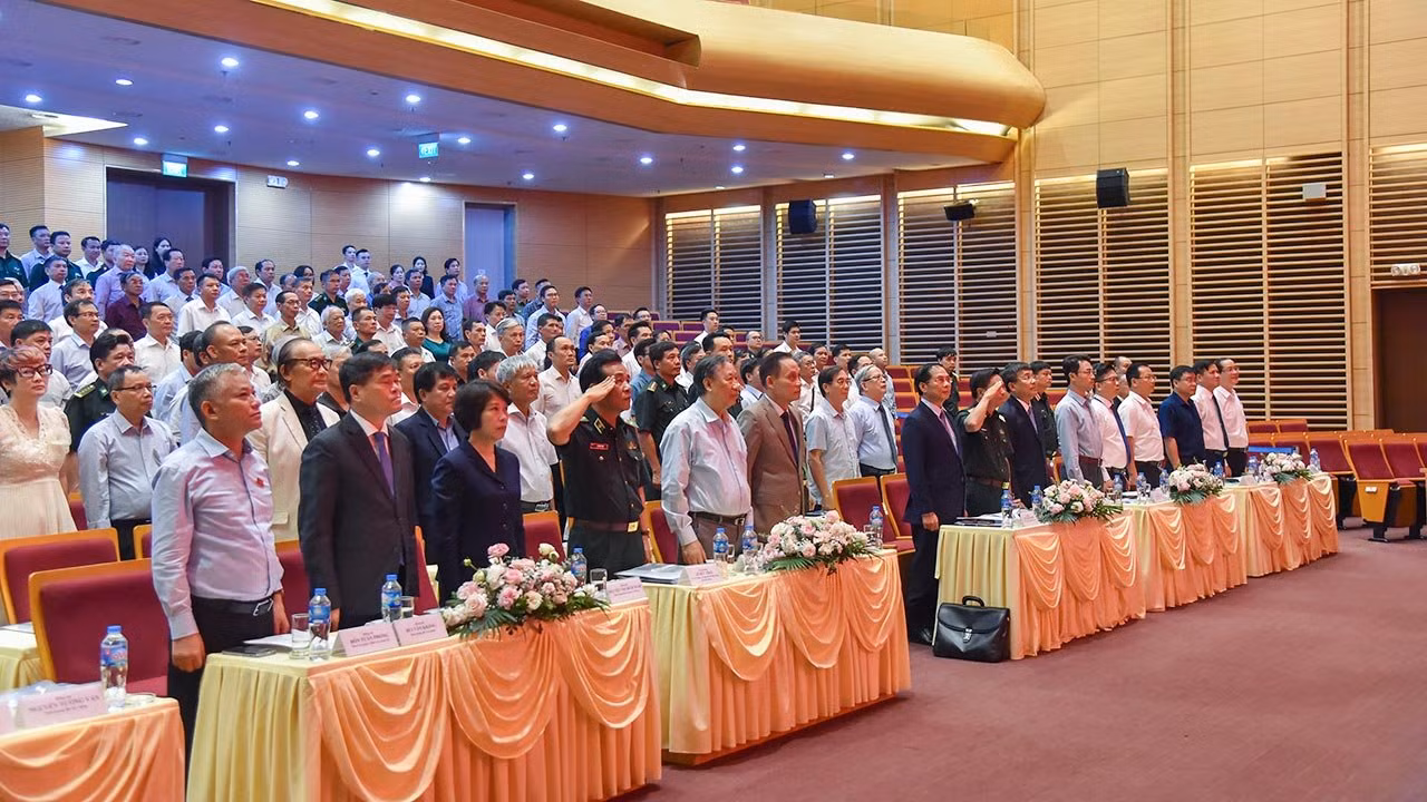 Các đại biểu tham dự hội nghị làm Lễ chào cờ. (Ảnh: TRUNG HƯNG)