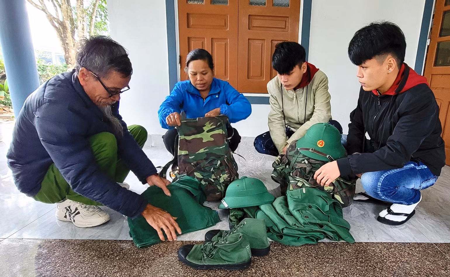 Ông Phạm Công Tiến giúp đỡ, hướng dẫn hai con trai sắp đặt ba lô, quân tư trang cá nhân trước ngày lên đường nhập ngũ.