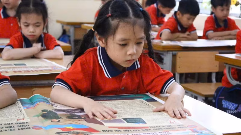 Học sinh Trường tiểu học Sông Cầu, thành phố Bắc Kạn, trải nghiệm phụ san đặc biệt. (Ảnh: TIẾN TRÌNH)