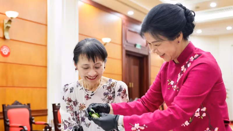 Hai phu nhân cùng làm bánh cốm truyền thống. (Ảnh: BNG) Hai phu nhân cùng làm bánh cốm truyền thống. (Ảnh: BNG)