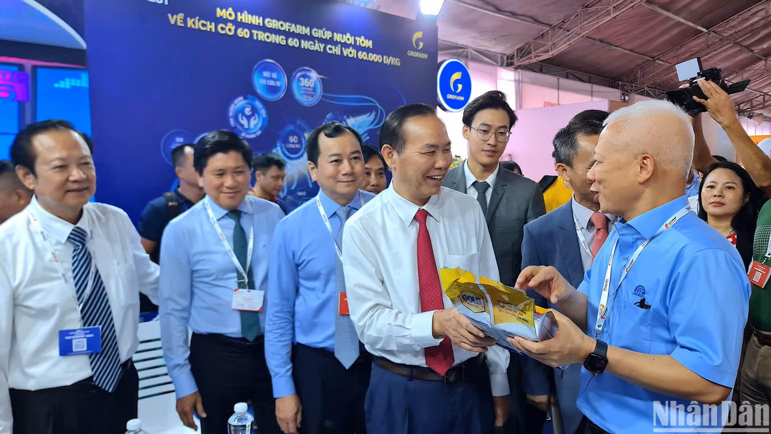 Thứ trưởng Nông nghiệp và Phát triển nông thôn Phùng Đức Tiến (cà vạt đỏ) tham quan không gian trưng bày sản phẩm ngành tôm tại hội chợ triển lãm.