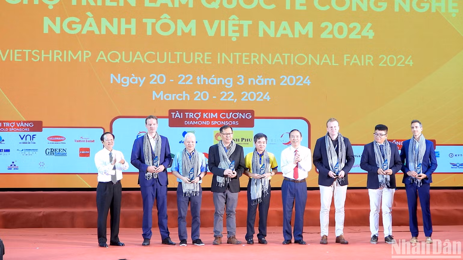 Thứ trưởng Nông nghiệp và Phát triển nông thôn Phùng Đức Tiến (cà vạt đỏ) tham quan không gian trưng bày sản phẩm ngành tôm tại hội chợ triển lãm.
