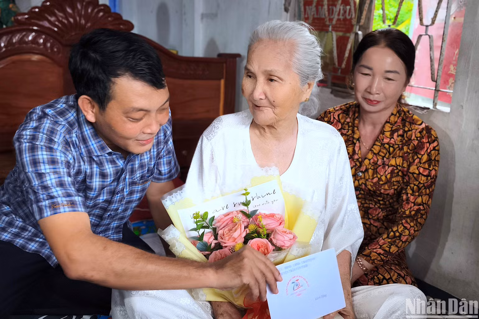Bí thư Huyện ủy Trần Văn Thời (tỉnh Cà Mau) Nguyễn Minh Nhứt (bìa trái) tặng quà Mẹ Việt Nam Anh hùng Võ Thị Nhành.