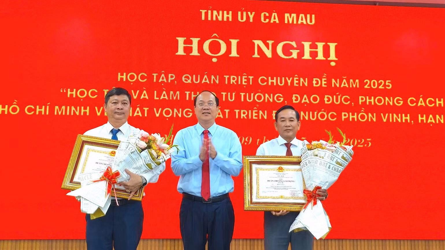 Bí thư Tỉnh ủy Cà Mau Nguyễn Hồ Hải (giữa) trao tặng Huân chương Lao động Hạng Nhì cho 2 cá nhân cán bộ, đảng viên tại hội nghị quán triệt.