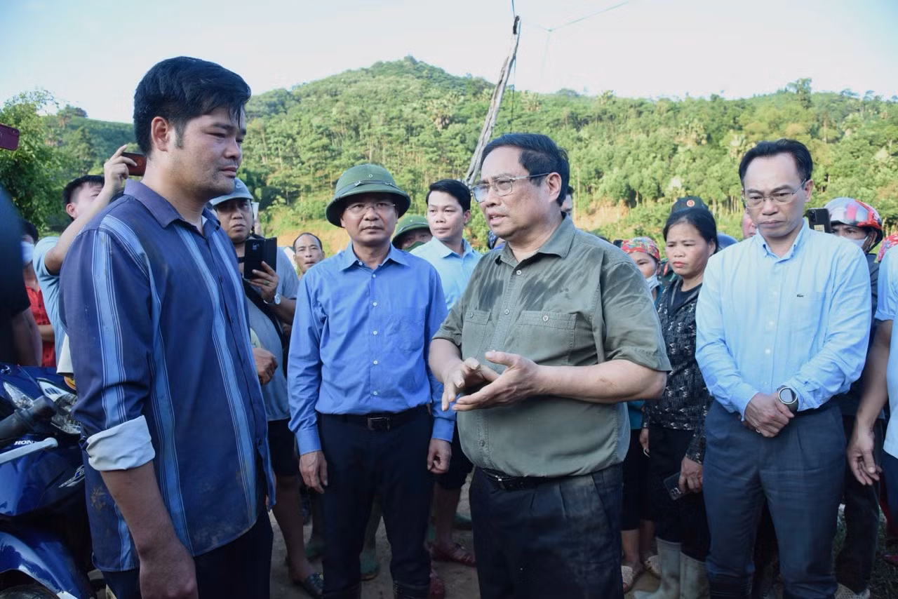 Thủ tướng Phạm Minh Chính thăm hỏi một người dân Làng Nủ có thân nhân thiệt mạng trong trận lũ quét vừa qua. (Ảnh: TRẦN HẢI)