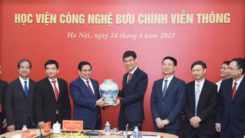 Thủ tướng Phạm Minh Chính tặng quà lưu niệm cho Học viện Công nghệ Bưu chính Viễn thông. (Ảnh: TRẦN HẢI)