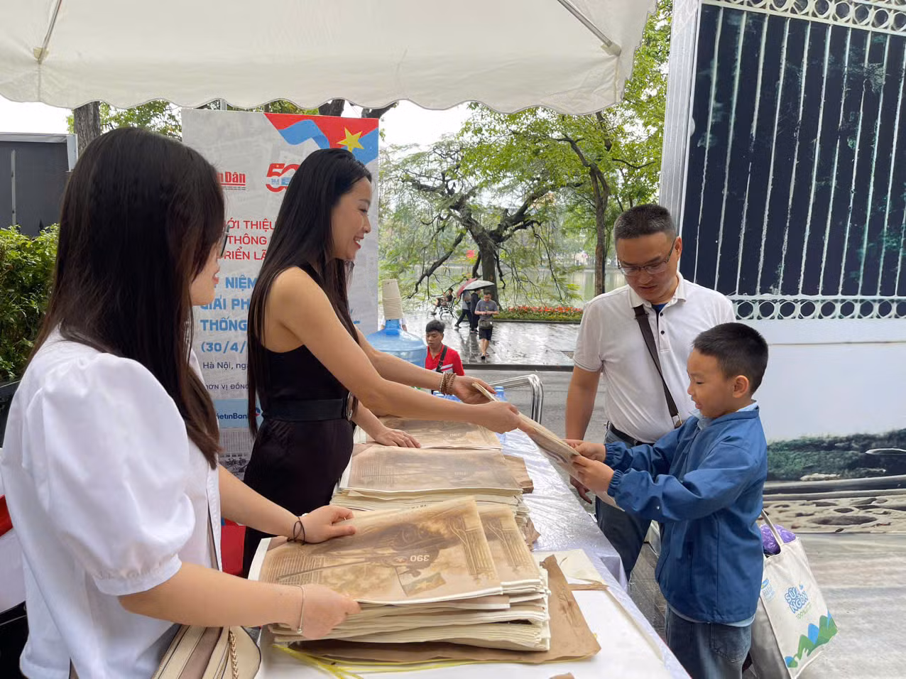 Anh Phạm Công Pháp cùng con trai nhận phụ san đặc biệt của Báo Nhân Dân.