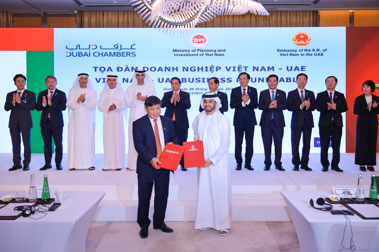 Đại diện lãnh đạo Vietjet (trái) và Emirates (phải) trao thỏa thuận hợp tác mở rộng kết nối quốc tế trước sự chứng kiến của Thủ tướng Phạm Minh Chính (giữa) tại Dubai, UAE.