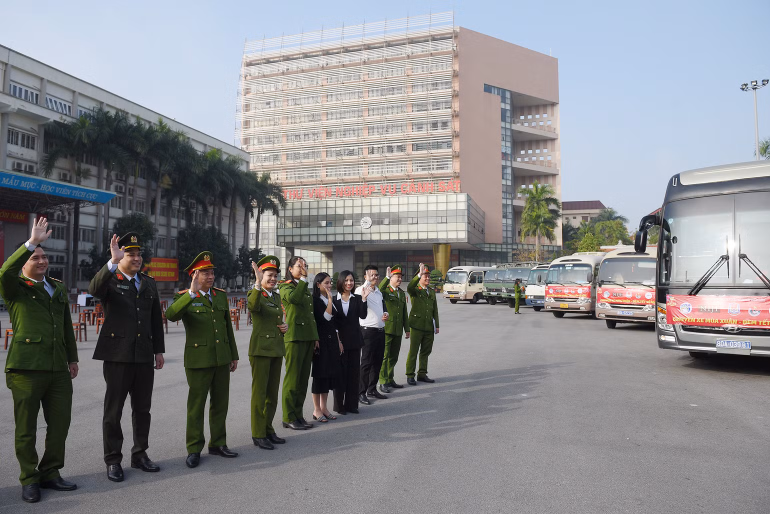 Các đại biểu vẫy chào đoàn xe lăn bánh, đưa các sinh viên về quê đón Tết.