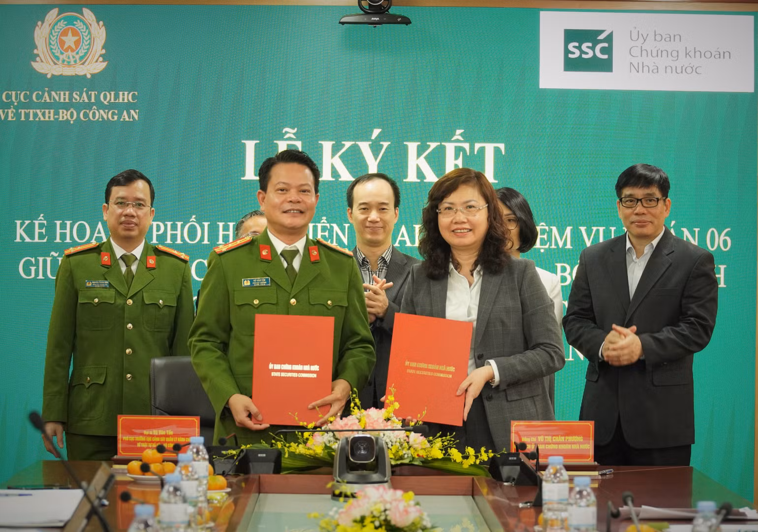 Chủ tịch Ủy ban Chứng khoán Nhà nước Vũ Thị Chân Phương và Đại tá Vũ Văn Tấn, Phó Cục trưởng Cục Cảnh sát Quản lý hành chính về trật tự xã hội- Bộ Công an trao Biên bản ký kết.