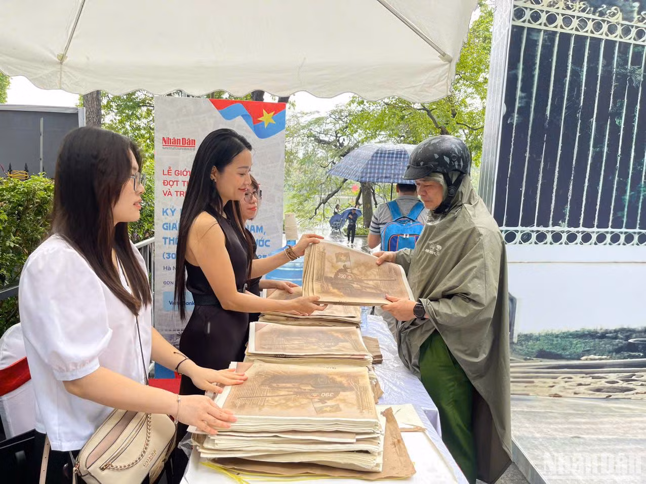 Nhiều độc giả không quản đường xa, trời mưa đến nhận phụ san đặc biệt của Báo Nhân Dân.
