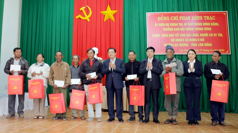 Đồng chí Phan Đình Trạc và các đồng chí Trần Đình Văn, Nguyễn Thị Thu Hà trao quà Tết tặng các hộ nghèo, già làng, người có uy tín xã Đưng K'Nớ, huyện Lạc Dương.