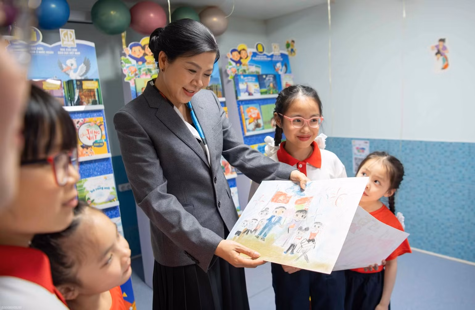 Các bạn nhỏ khoe tranh vẽ với Phu nhân Tổng Bí thư Ngô Phương Ly.