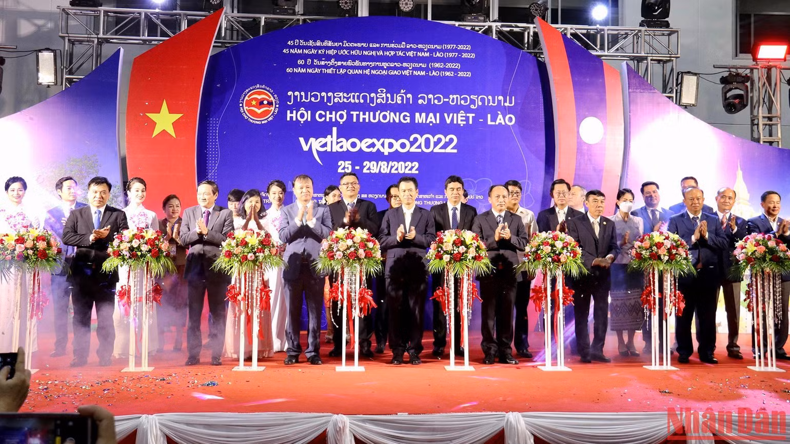 Các đại biểu làm lễ cắt băng khai mạc Hội chợ thương mại Việt-Lào 2022. (Ảnh: Trịnh Dũng)