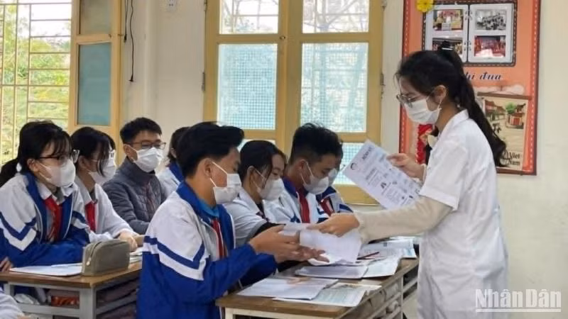 Nhân viên y tế phát tờ rơi tuyên truyền phòng, chống dịch sởi trong trường học ở thành phố Thái Bình.