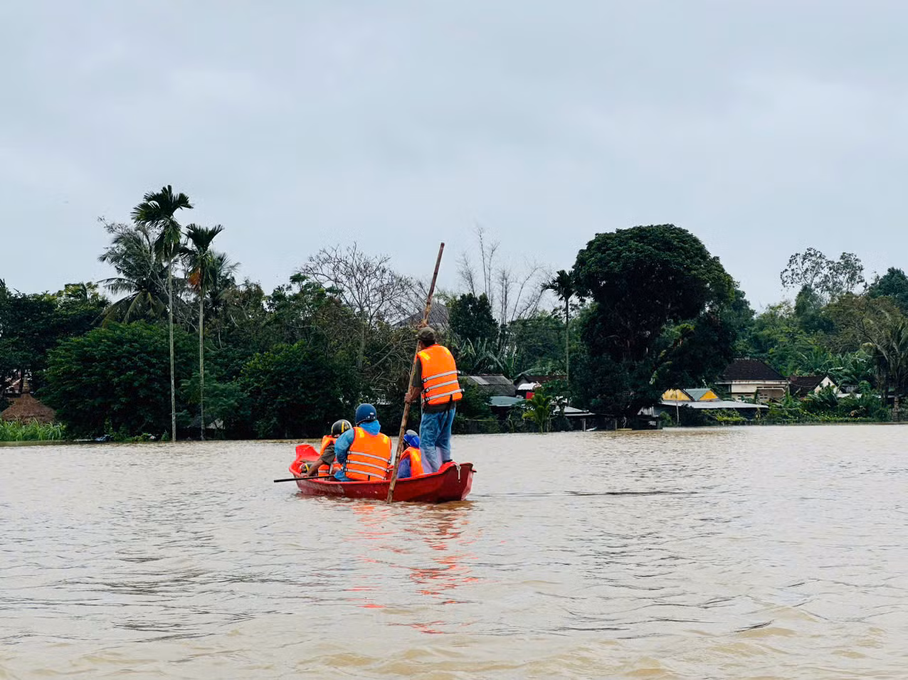 Các lực lượng chức năng hỗ trợ di dời người dân vùng bị ngập lũ ở phường Phổ Minh, thị xã Đức Phổ đến nơi an toàn.