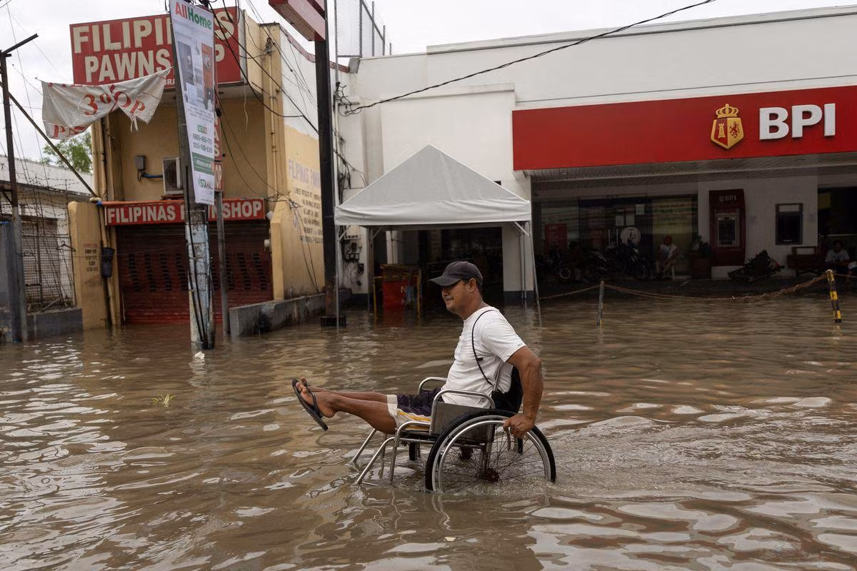 Một người đàn ông lội qua dòng nước lũ trên chiếc xe lăn ở Imus, tỉnh Cavite, Philippines, ngày 30/10. (Ảnh: Reuters) Một người đàn ông lội qua dòng nước lũ trên chiếc xe lăn ở Imus, tỉnh Cavite, Philippines, ngày 30/10. (Ảnh: Reuters)