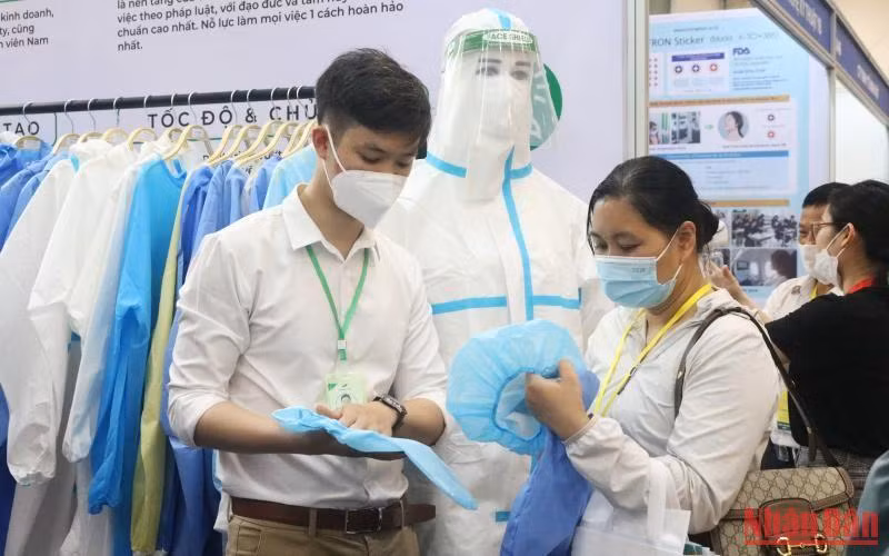 Khách tham quan sản phẩm đồ bảo hộ y tế tại gian hàng của Công ty cổ phần Sản xuất thương mại dệt may Nam Dương tại Triển lãm Y tế ở Thành phố Hồ Chí Minh.