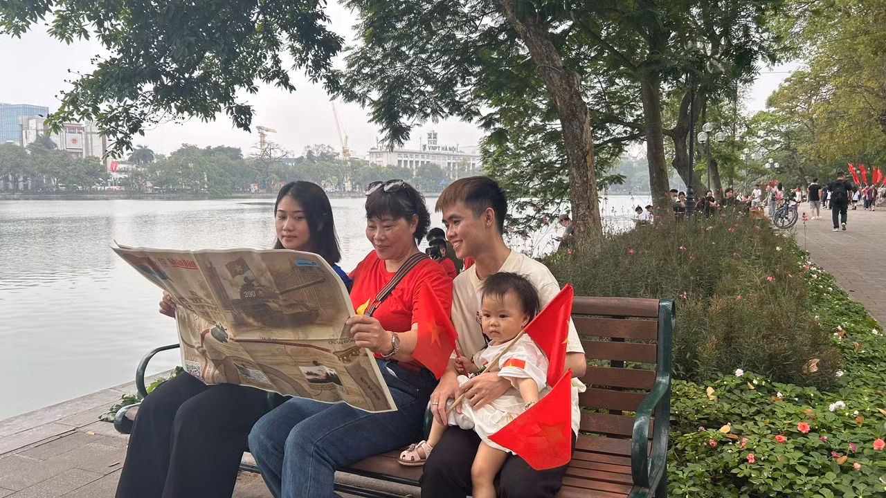Gia đình bà Hoa gồm 3 thế hệ trải nghiệm đọc tờ phụ san đặc biệt của Báo Nhân Dân
