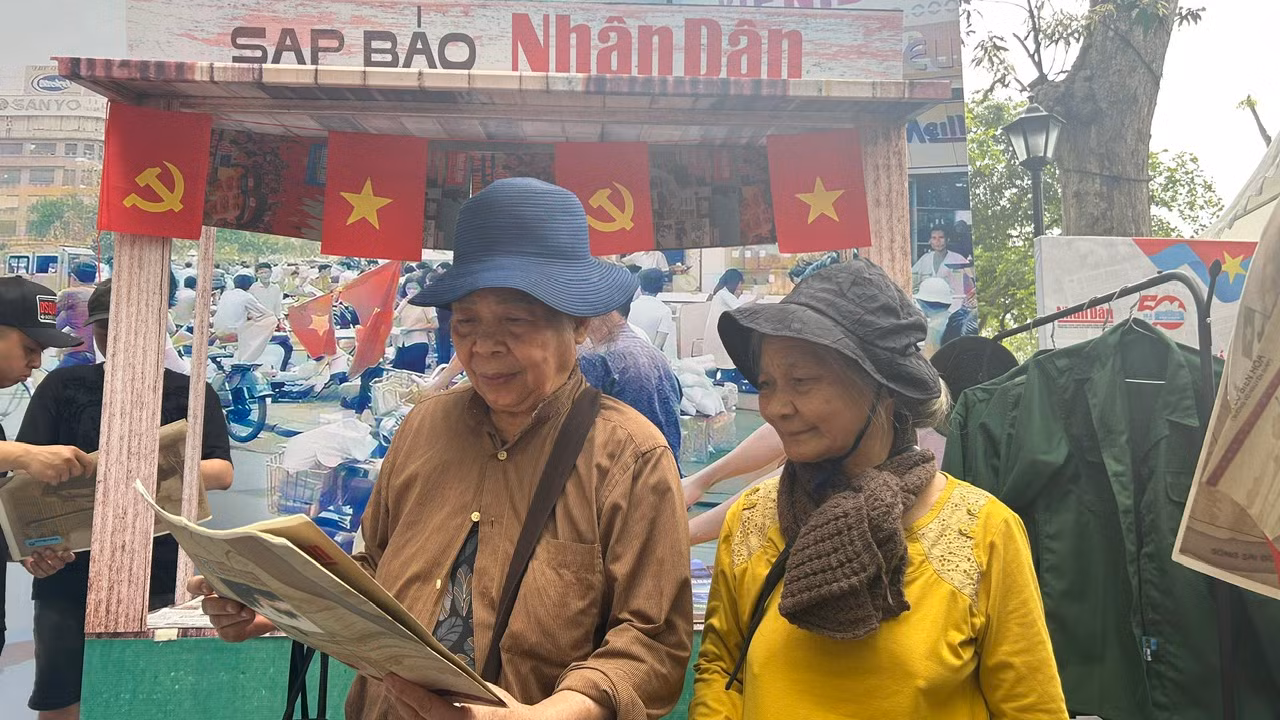 Bà Nguyễn Thị Nga xúc động khi cầm phụ san 30/4 Báo Nhân Dân trên tay.