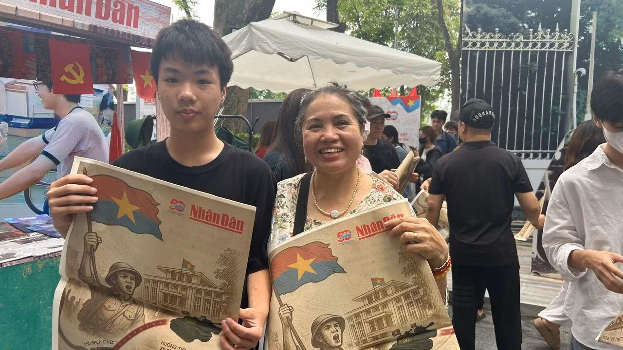 Bà Thu Hạnh (Hoàn Kiếm, Hà Nội) cùng cháu nội dậy từ sớm, xếp hàng nhận phụ san đặc biệt của Báo Nhân Dân.