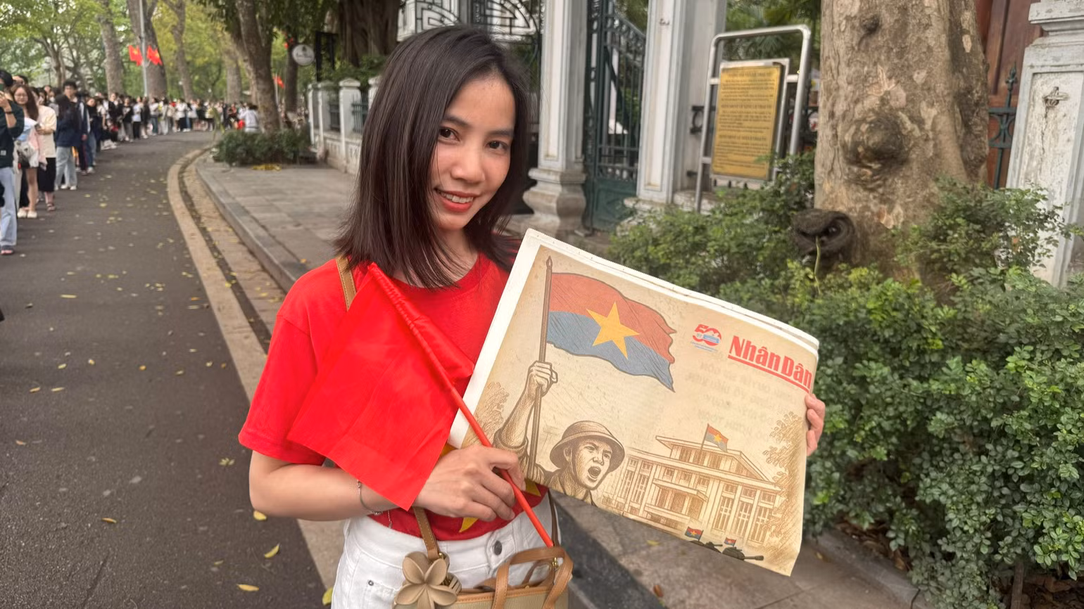 Bạn Trương Thị Học, 29 tuổi, kỹ sư điện tử đến từ Hà Nam thích thú bên phụ san đặc biệt của Báo Nhân Dân.