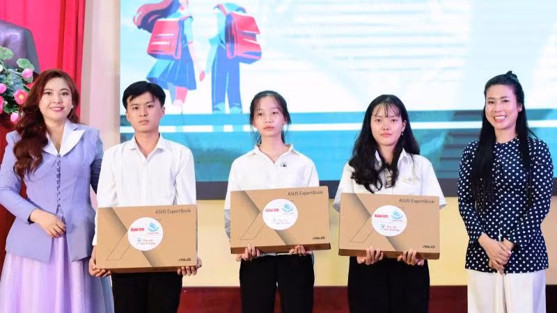 Đại diện Quỹ khuyến học Vinacam trao máy tính xách tay cho sinh viên khó khăn, thiếu thiết bị học tập. (Ảnh: HOÀNG TRUNG)