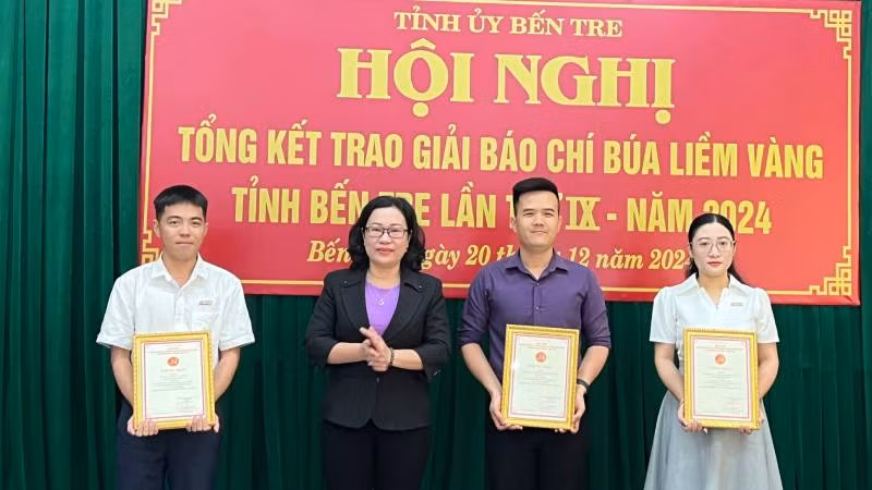 Trưởng Ban Tuyên giáo Tỉnh ủy Bến Tre Nguyễn Trúc Hạnh trao giải Ba cho các tác giả. (Ảnh: HOÀNG TRUNG)