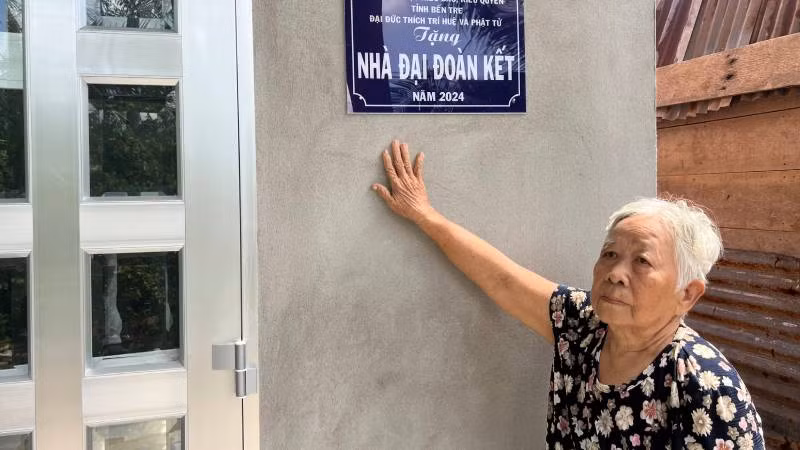 Bà Nguyễn Thị Sữa (ngụ xã An Phước, huyện Châu Thành) bên căn nhà Đại đoàn kết vừa khánh thành, đưa vào sử dụng. (Ảnh: HOÀNG TRUNG)