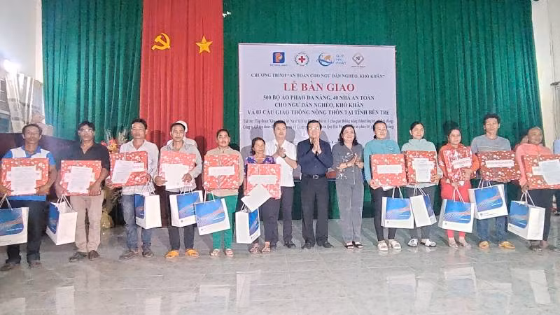 Đoàn công tác tặng quà cho các hộ dân nhận nhà mới.